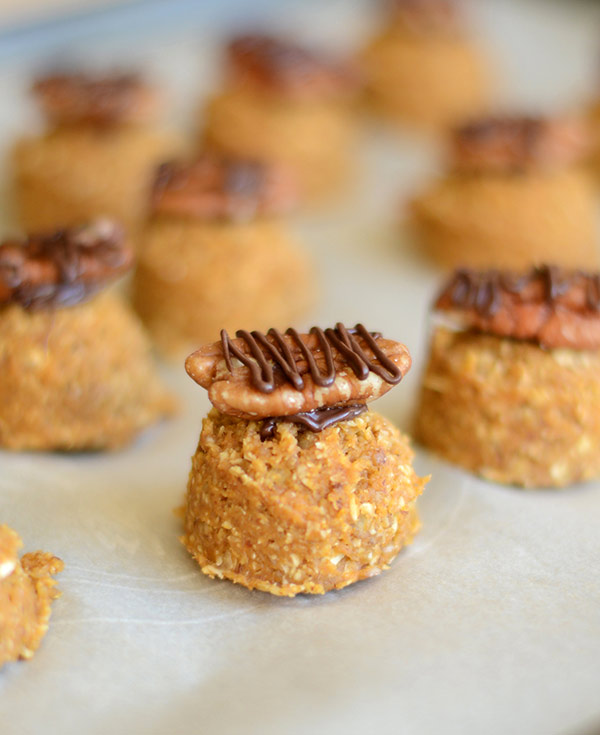 Tray of frozen pumpkin bites with pecans and chocolate drizzle.