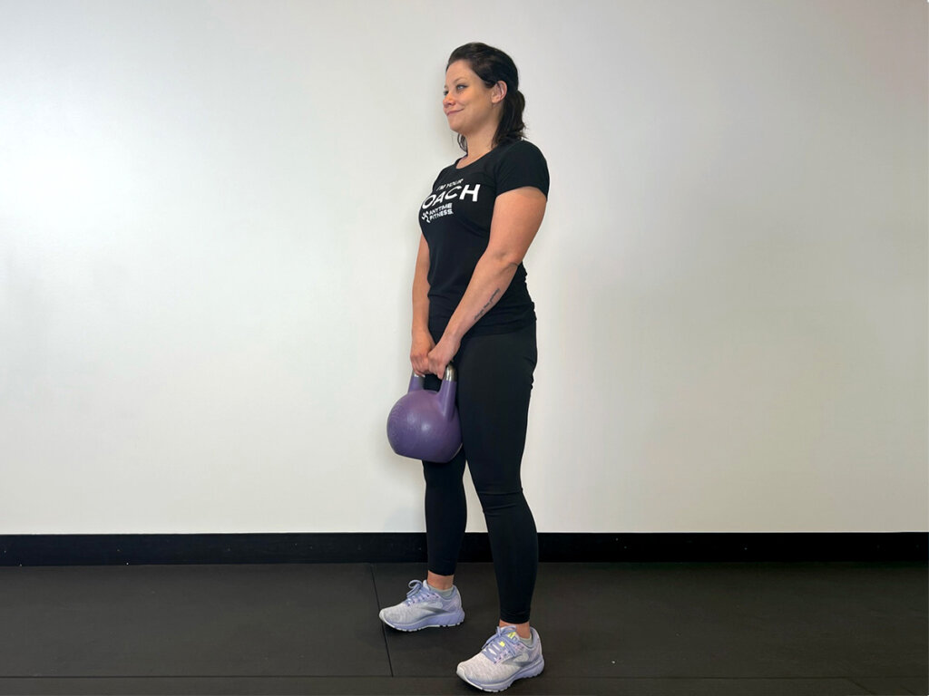 Coach standing upright while still holding kettlebell.