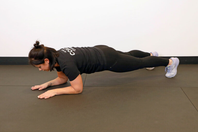 Coach holding a plank position on forearms.