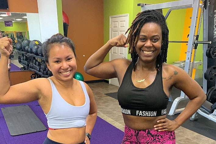 Jasmine and another gym-goer flexing their biceps.