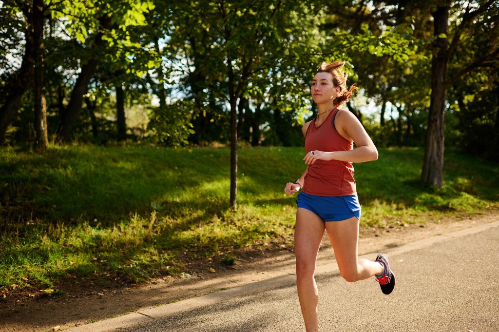 A woman running on a paved outdoor trail.