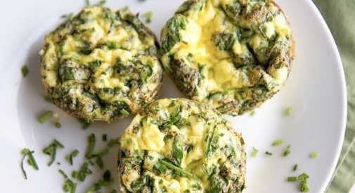 Three spinach, feta, and egg bites on a white plate.