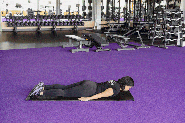 Coach performing an a-raise on a gym mat.