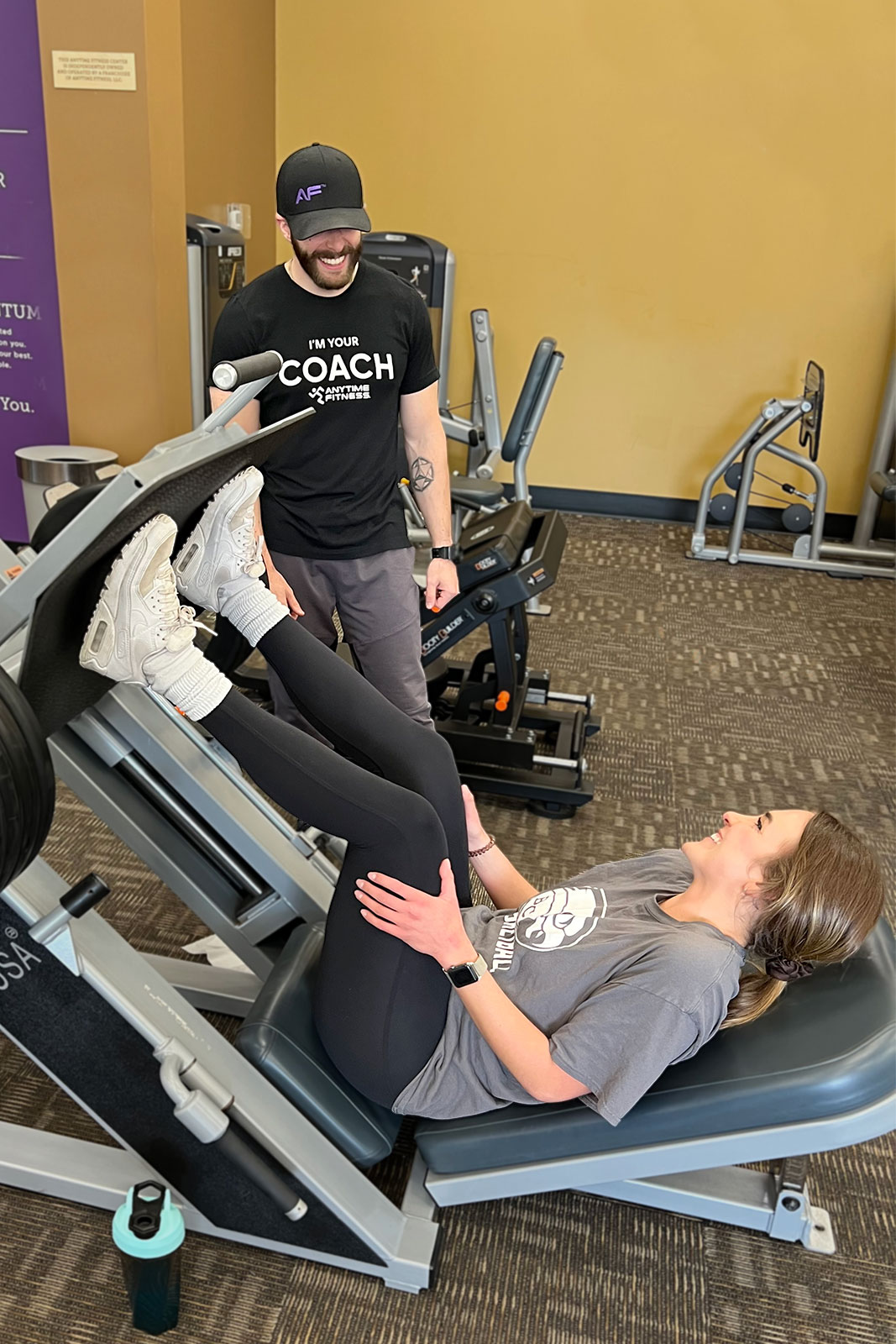 Molly at the leg press machine, being encouraged by her Coach, Adam.