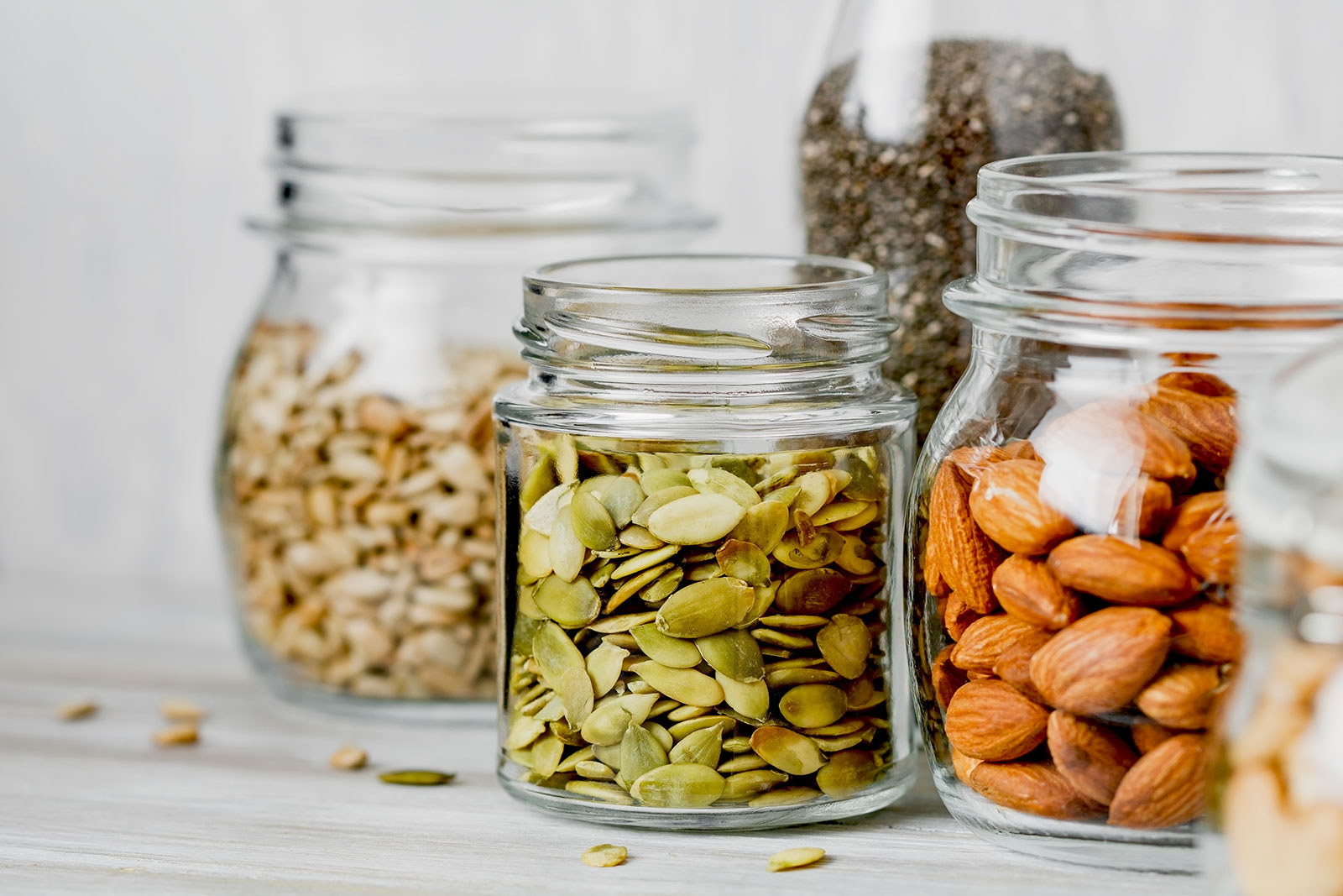 Jars of cashews, pumpkins seeds, and almonds.
