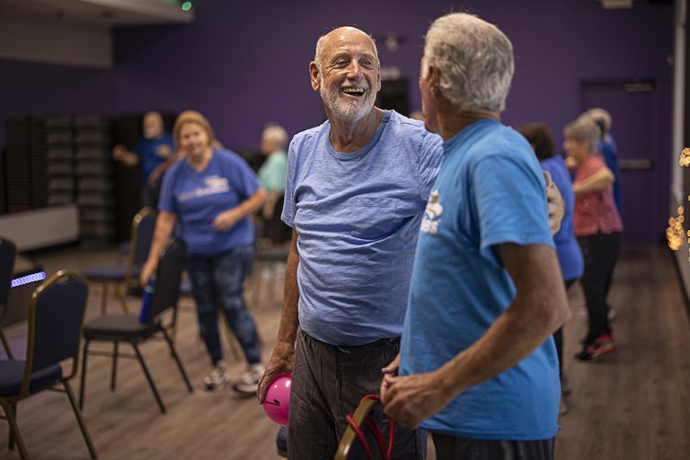 Joe and a workout buddy greeting each other at a group training class in the gym.