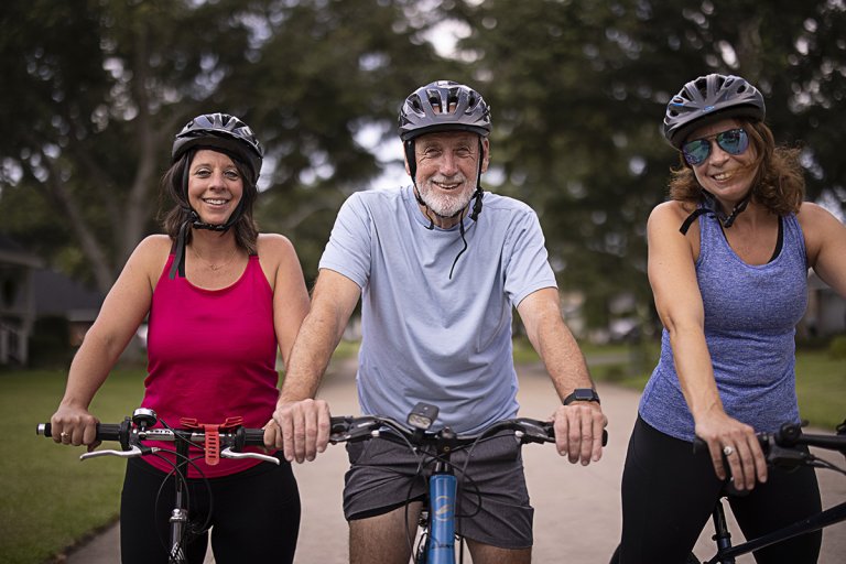 Joe and his daughters riding bicycles in the neighborhood.