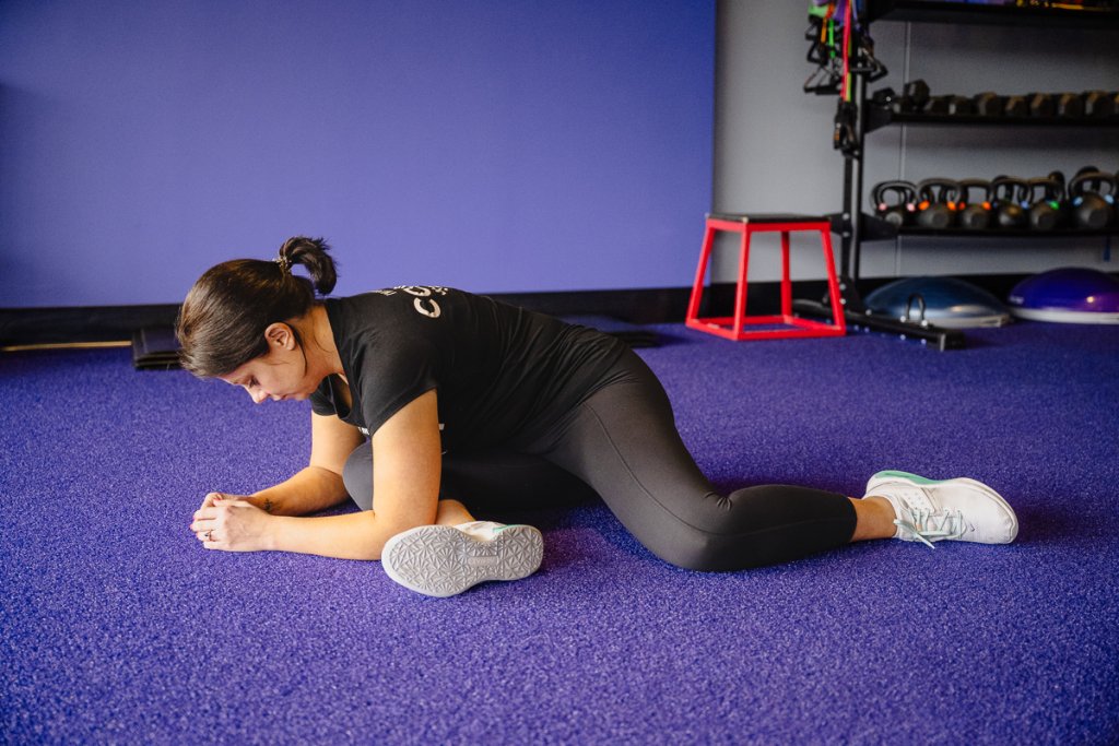 Coach Heather demonstrating a modified pigeon stretch.