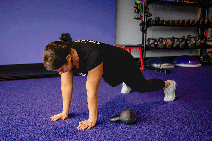 Coach Heather demonstrating a high plank pull through.
