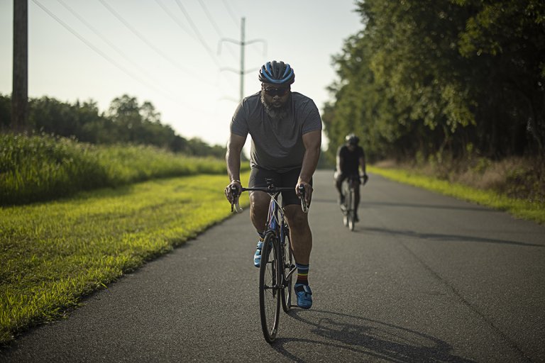 Mark cycling in the foreground with Coach Devon in the background, cycling just behind Mark.