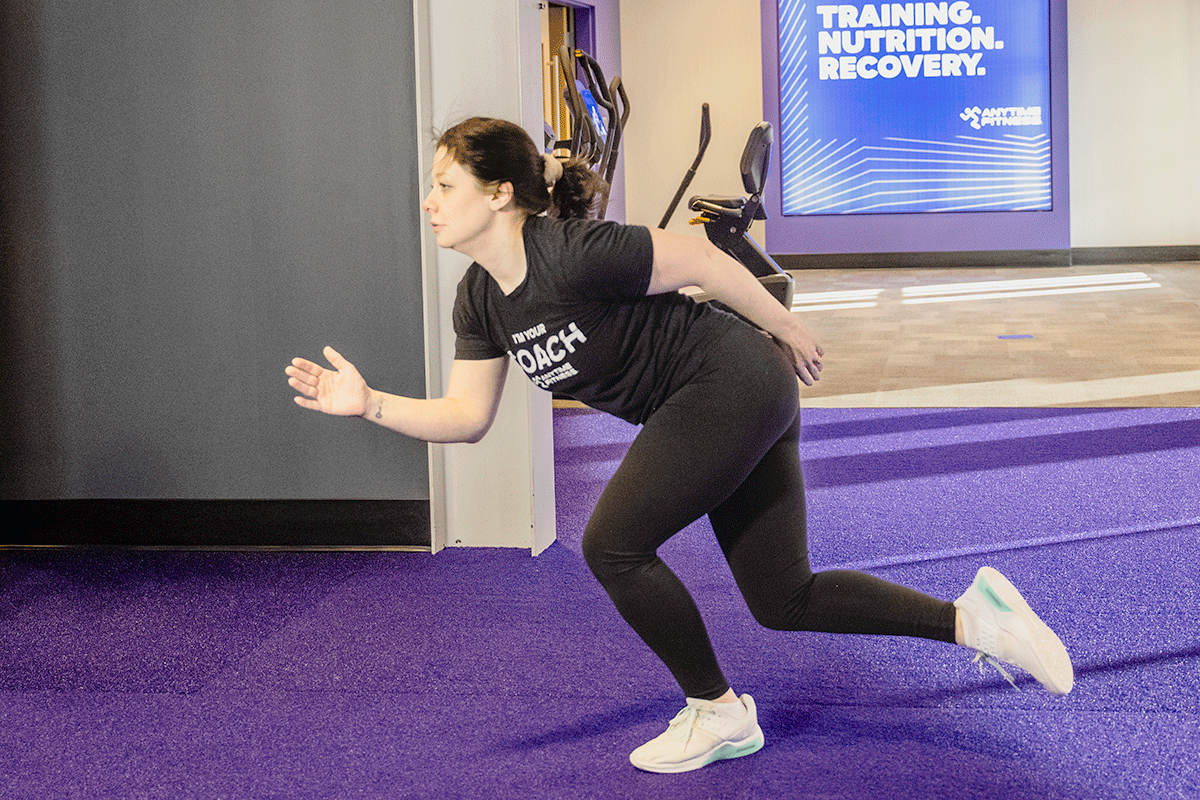 Woman in a gym jumping back and forth during a high-intensity workout.
