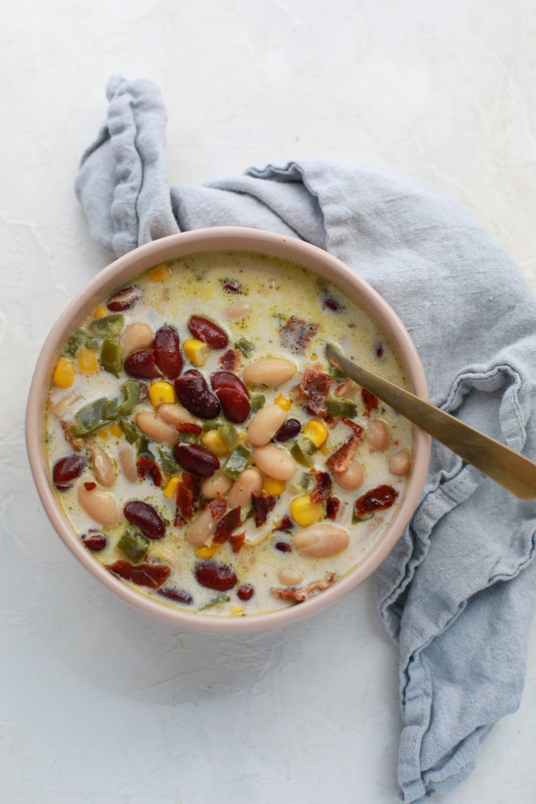 Jalapeño Popper Bean Soup in a pink bowl with a spoon and napkin