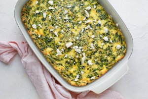 Spinach and feta egg casserole, in a baking dish with a napkin nearby.
