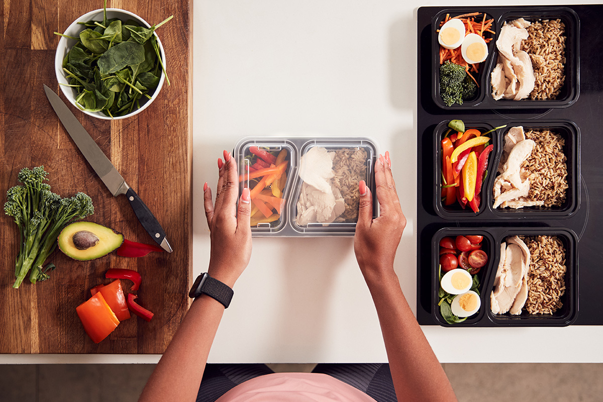 Overview of a person packing protein- and nutrient-dense foods into to-go containers.