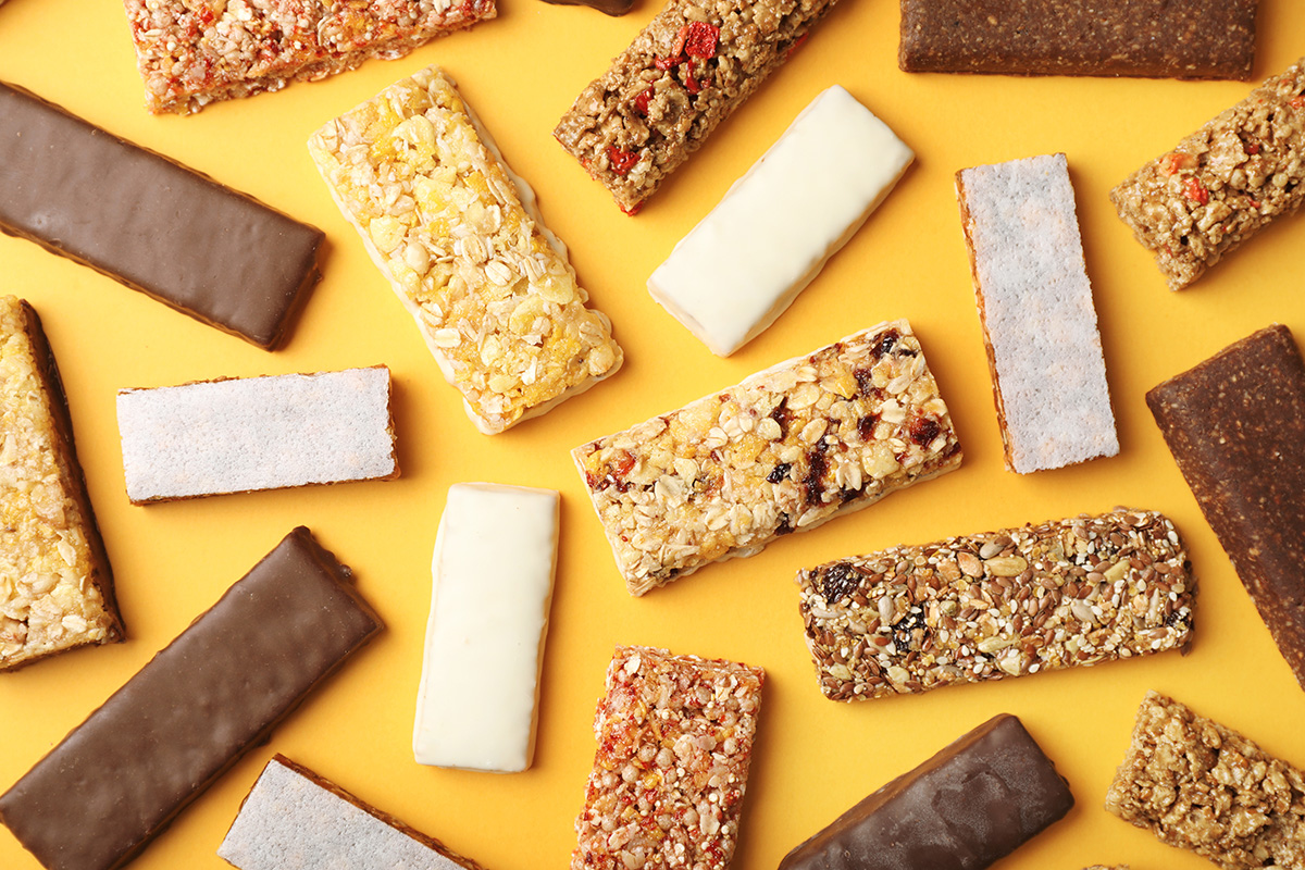 Various protein bars on a yellow background.