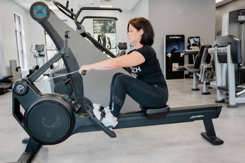 AnytimeFitness_RowingMachine_Step1 Coach Heather demonstrating the catch on a rowing machine